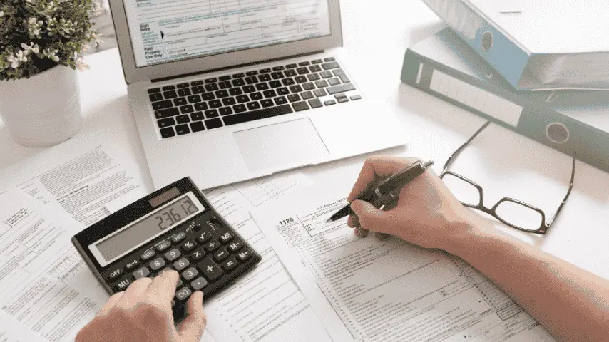 Tax forms, calculator and laptop prepared for tax season